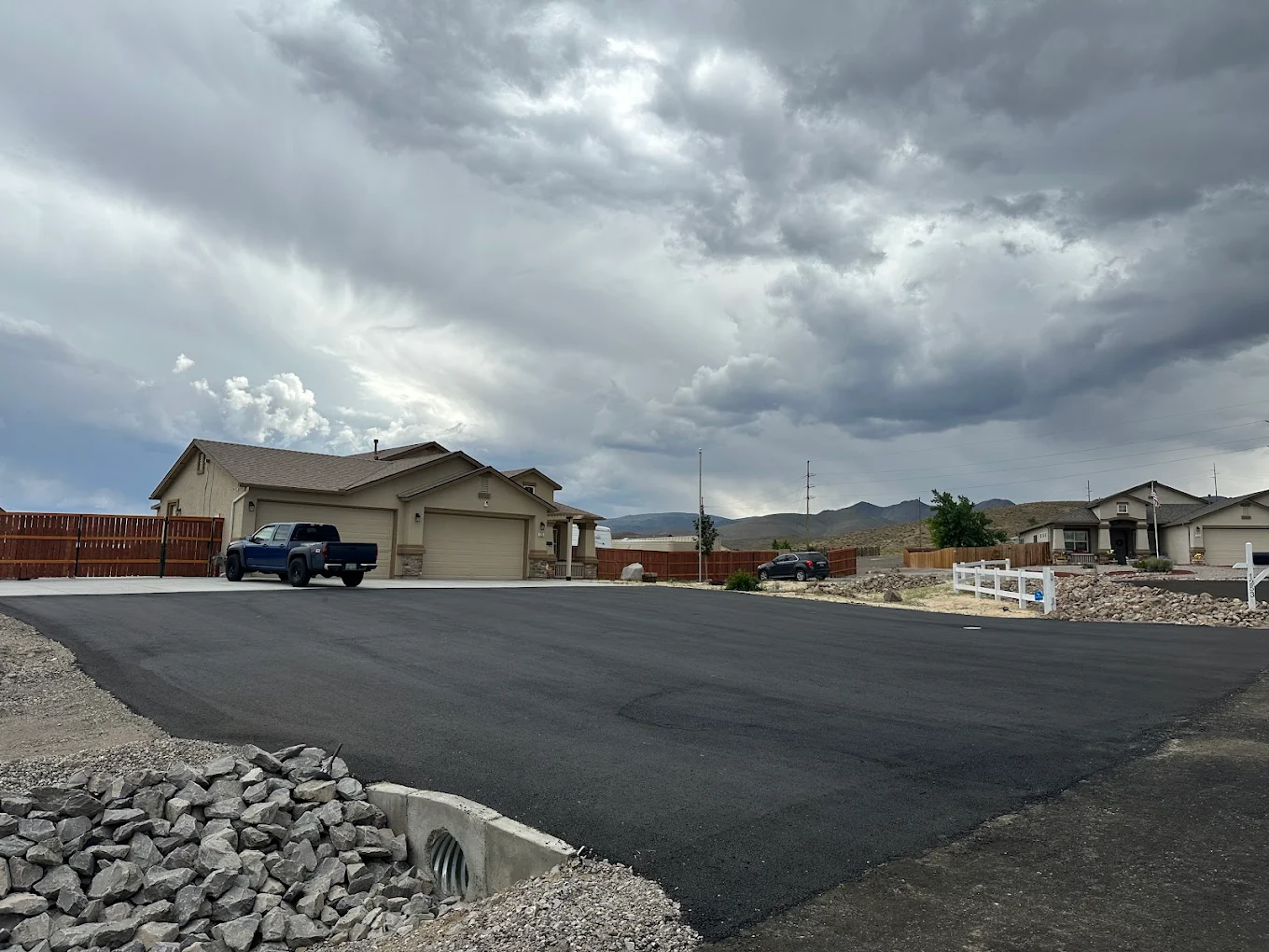 Freshly paved cul-de-sac with stormy mountain skies overhead