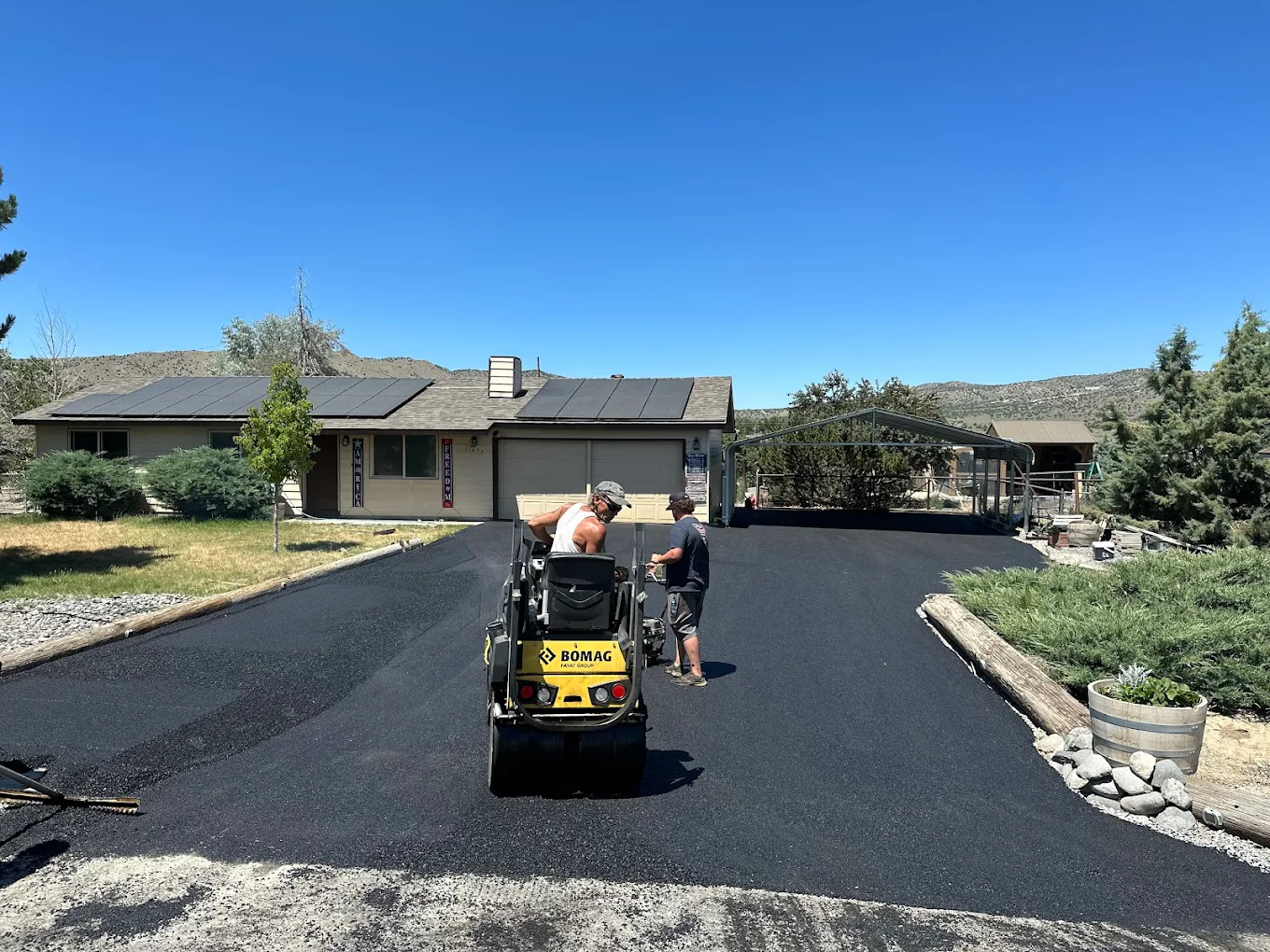 Residential driveway paved with mountains rising behind the home