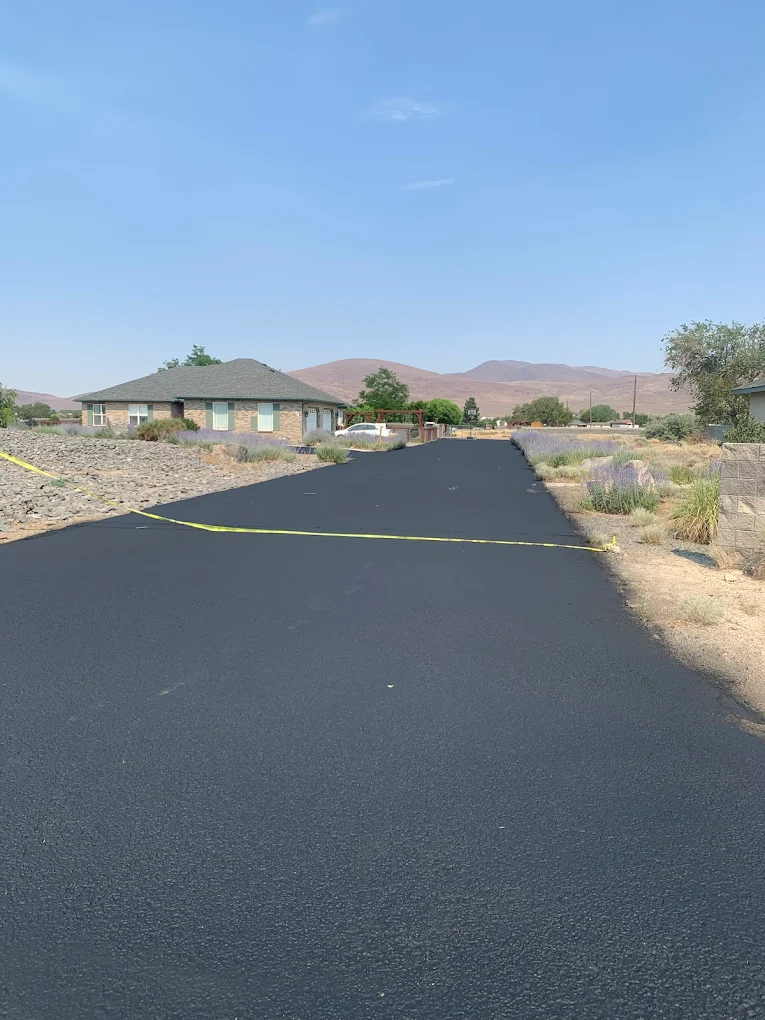 Freshly paved asphalt road with Western Colorado mountains in the background