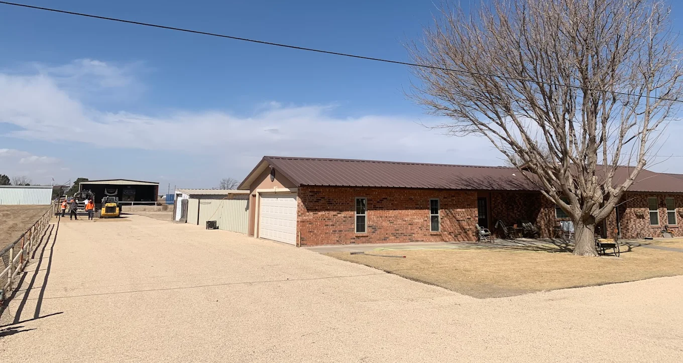 Ranch property in Western Colorado with a chip-sealed access drive serving a brick outbuilding